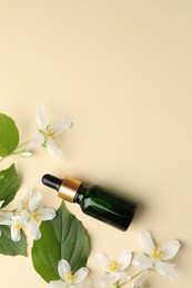 Photo of Essential oil, beautiful jasmine flowers and leaves on beige background, flat lay. Space for text