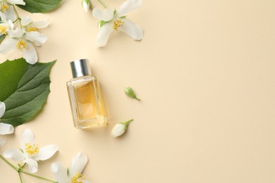 Photo of Bottle of perfume, beautiful jasmine flowers and green leaves on beige background, flat lay. Space for text