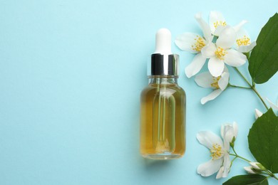 Photo of Essential oil, jasmine flowers and green leaves on light blue background, flat lay. Space for text