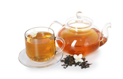 Photo of Aromatic jasmine tea in glass cup, teapot, flowers and dried leaves isolated on white