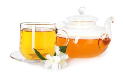 Photo of Aromatic jasmine tea in glass cup, teapot, flowers and green leaves isolated on white