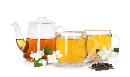 Photo of Aromatic jasmine tea in glass cups, teapot, flowers and leaves isolated on white