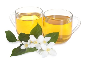 Photo of Aromatic jasmine tea in glass cups, flowers and green leaves isolated on white