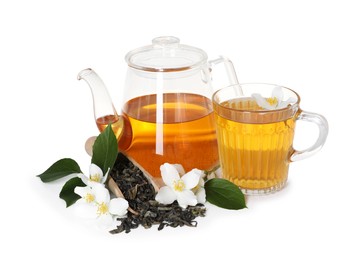 Photo of Aromatic jasmine tea in glass cup, teapot, flowers and dried leaves isolated on white