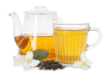 Photo of Aromatic jasmine tea in glass cup, teapot, flowers and dried leaves isolated on white