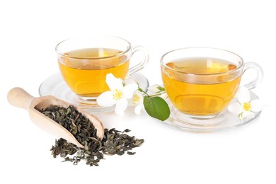 Photo of Aromatic jasmine tea in glass cups, flowers and dried leaves isolated on white