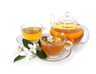 Photo of Aromatic jasmine tea in glass cups, teapot, flowers and green leaves isolated on white