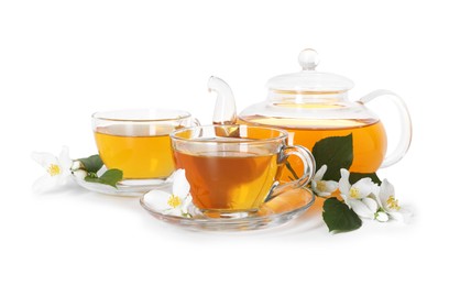 Photo of Aromatic jasmine tea in glass cups, teapot, flowers and green leaves isolated on white