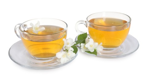 Photo of Aromatic jasmine tea in glass cups, flowers and green leaves isolated on white