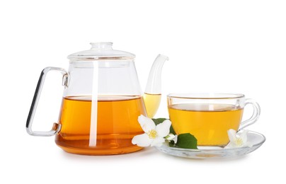 Photo of Aromatic jasmine tea in glass cup, teapot and flowers isolated on white
