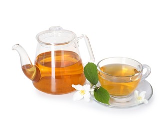 Photo of Aromatic jasmine tea in glass cup, teapot and flowers isolated on white