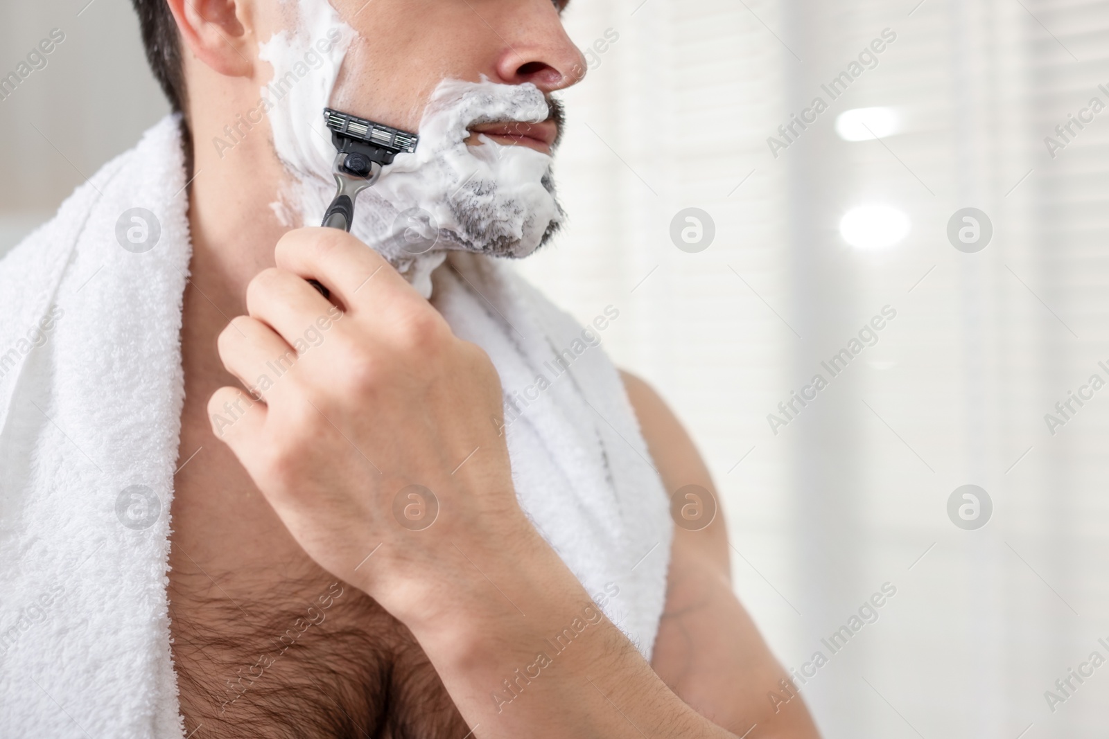 Man shaving with razor at home, closeup. Space for text Photo of Man shaving with razor at home, closeup. Space for text