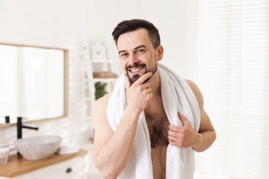 Photo of Portrait of smiling man before shaving in bathroom