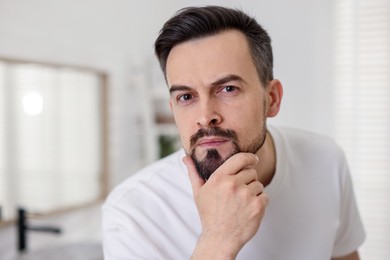 Photo of Portrait of handsome man before shaving in bathroom