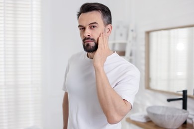 Photo of Portrait of handsome man before shaving in bathroom