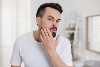 Photo of Portrait of handsome man before shaving in bathroom