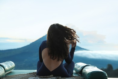 Photo of Beautiful woman enjoying picturesque view of mountains, back view