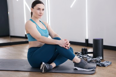 Photo of Woman with different sports equipment in fitness studio