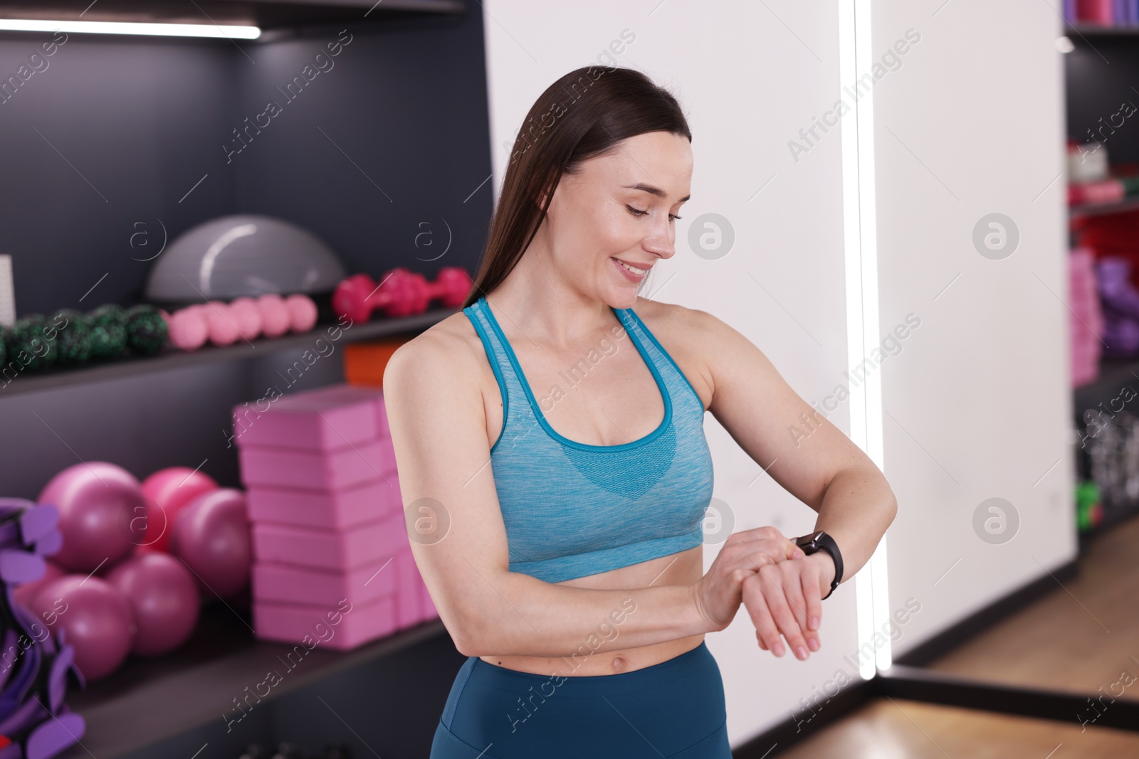Beautiful woman checking fitness tracker during training in studio Photo of Beautiful woman checking fitness tracker during training in studio