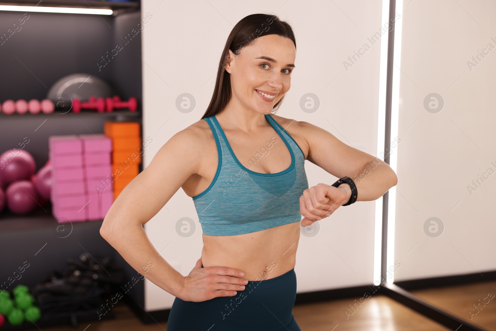 Beautiful woman checking fitness tracker during training in studio Photo of Beautiful woman checking fitness tracker during training in studio