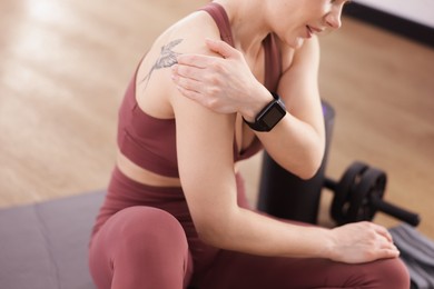 Photo of Sports injury. Woman with pain in shoulder indoors, closeup