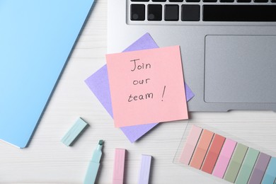 Photo of Paper note with phrase Join Our Team, laptop and stationery on white wooden table, flat lay