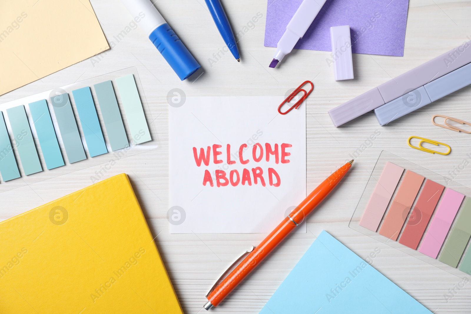 Paper note with phrase Welcome Aboard and stationery on white wooden table, flat lay Photo of Paper note with phrase Welcome Aboard and stationery on white wooden table, flat lay