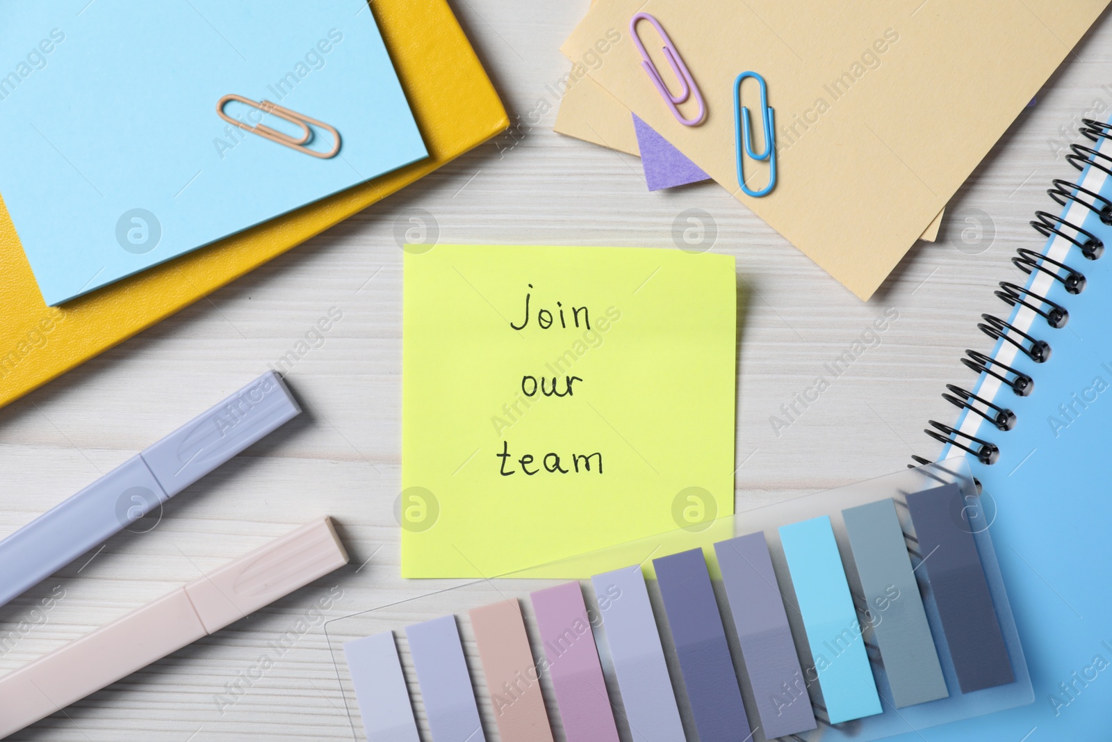 Photo of Paper note with phrase Join Our Team and stationery on wooden table, flat lay