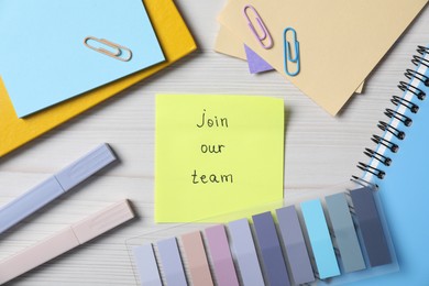Photo of Paper note with phrase Join Our Team and stationery on wooden table, flat lay