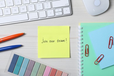 Photo of Paper note with phrase Join Our Team, keyboard and stationery on white wooden table, flat lay