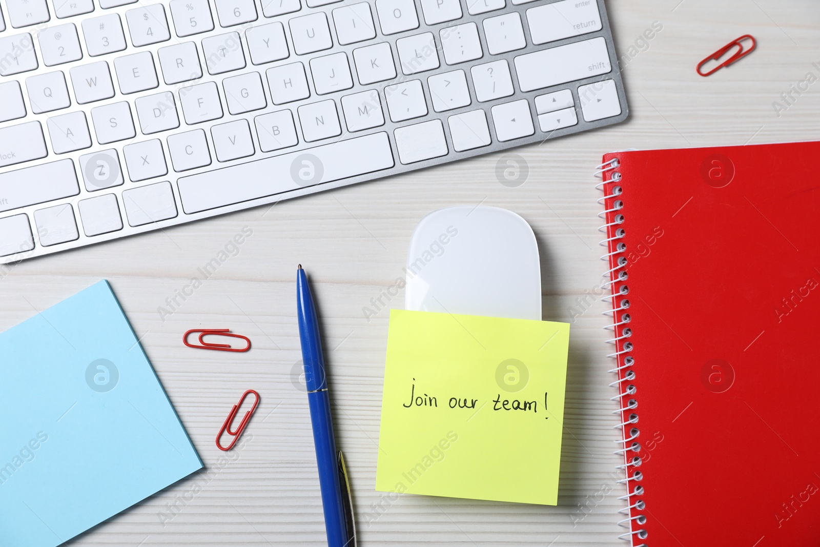 Photo of Paper note with phrase Join Our Team, keyboard and stationery on white wooden table, flat lay