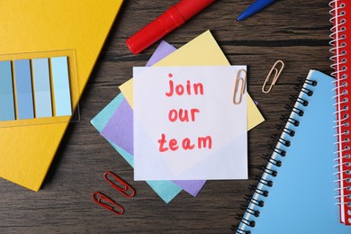 Photo of Paper note with phrase Join Our Team and stationery on wooden table, flat lay