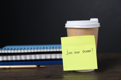 Photo of Paper note with phrase Join Our Team and cup of coffee on wooden table. Space for text
