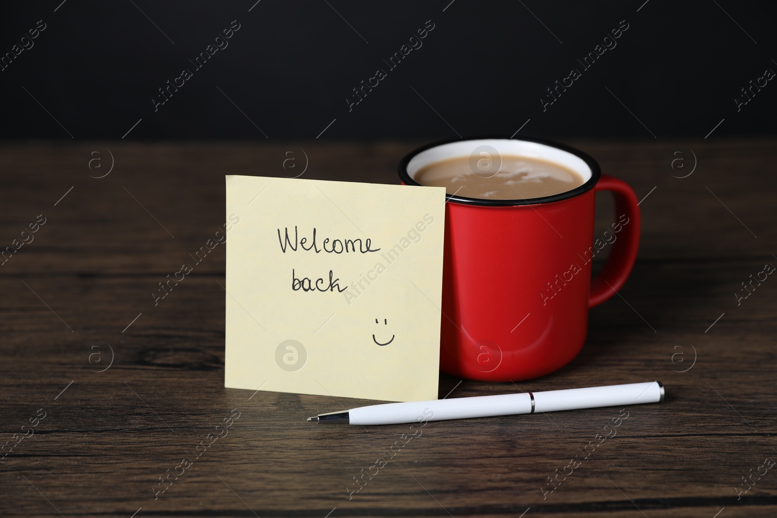 Paper note with phrase Welcome Back, pen and cup of coffee on wooden table Photo of Paper note with phrase Welcome Back, pen and cup of coffee on wooden table