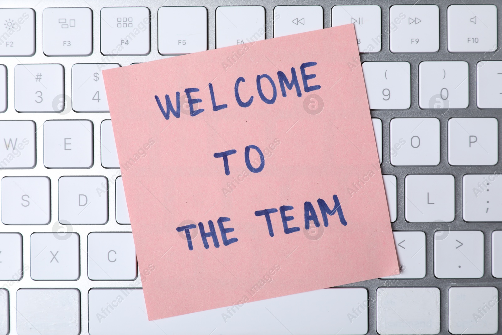 Photo of Paper note with phrase Welcome To The Team on keyboard, top view