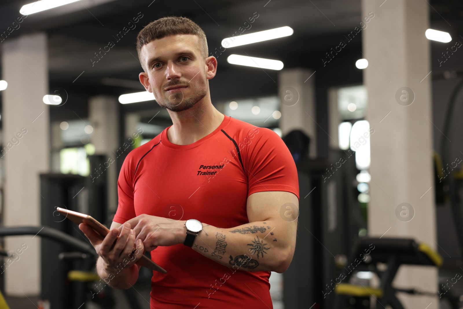 Personal trainer wearing t-shirt with inscription in gym Image of Personal trainer wearing t-shirt with inscription in gym