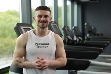 Image of Personal trainer wearing clothing with inscription in gym