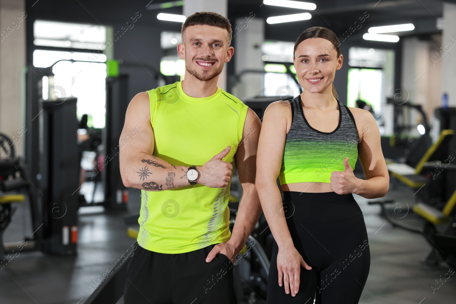 Personal trainers showing thumbs ups in gym Photo of Personal trainers showing thumbs ups in gym