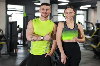 Photo of Personal trainers showing thumbs ups in gym