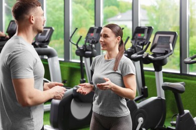 Photo of Professional personal trainers talking in sport center