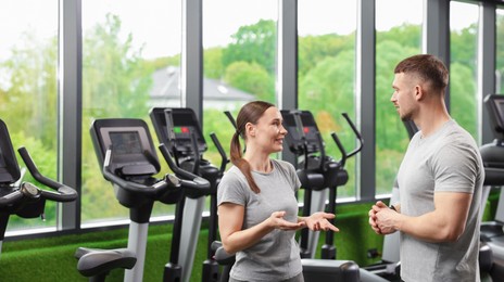 Photo of Professional personal trainers talking in sport center