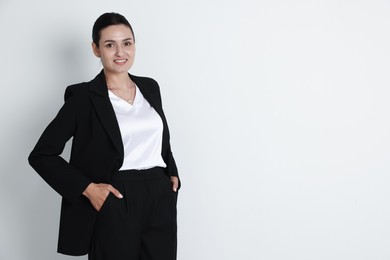 Photo of Confident business woman in suit on light background. Space for text