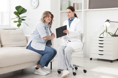Photo of Weight loss. Nutritionist consulting overweight woman in clinic
