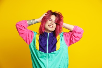 Photo of Beautiful woman with pink dyed hair on yellow background