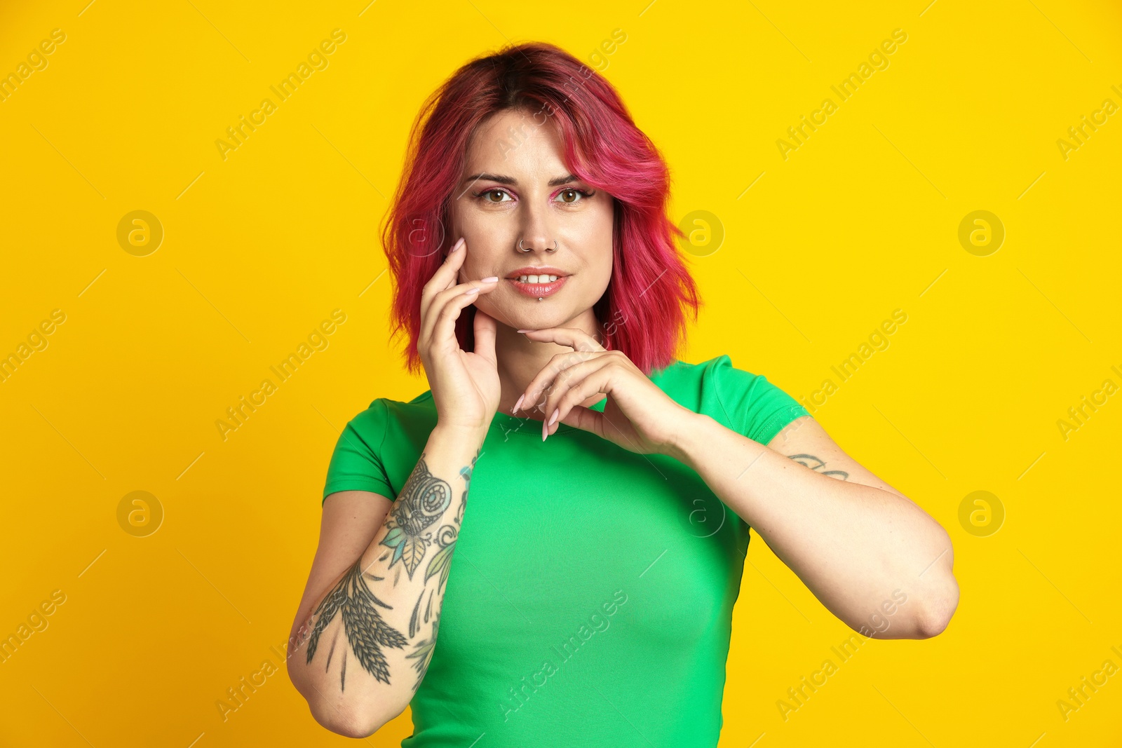 Beautiful woman with pink dyed hair on yellow background Photo of Beautiful woman with pink dyed hair on yellow background
