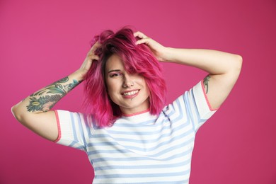 Photo of Beautiful woman with bright dyed hair on pink background