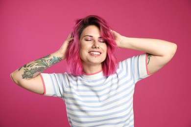 Photo of Beautiful woman with bright dyed hair on pink background