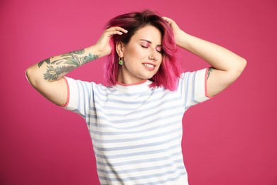 Photo of Beautiful woman with bright dyed hair on pink background