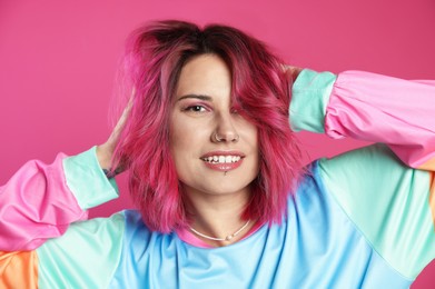 Photo of Beautiful woman with bright dyed hair on pink background