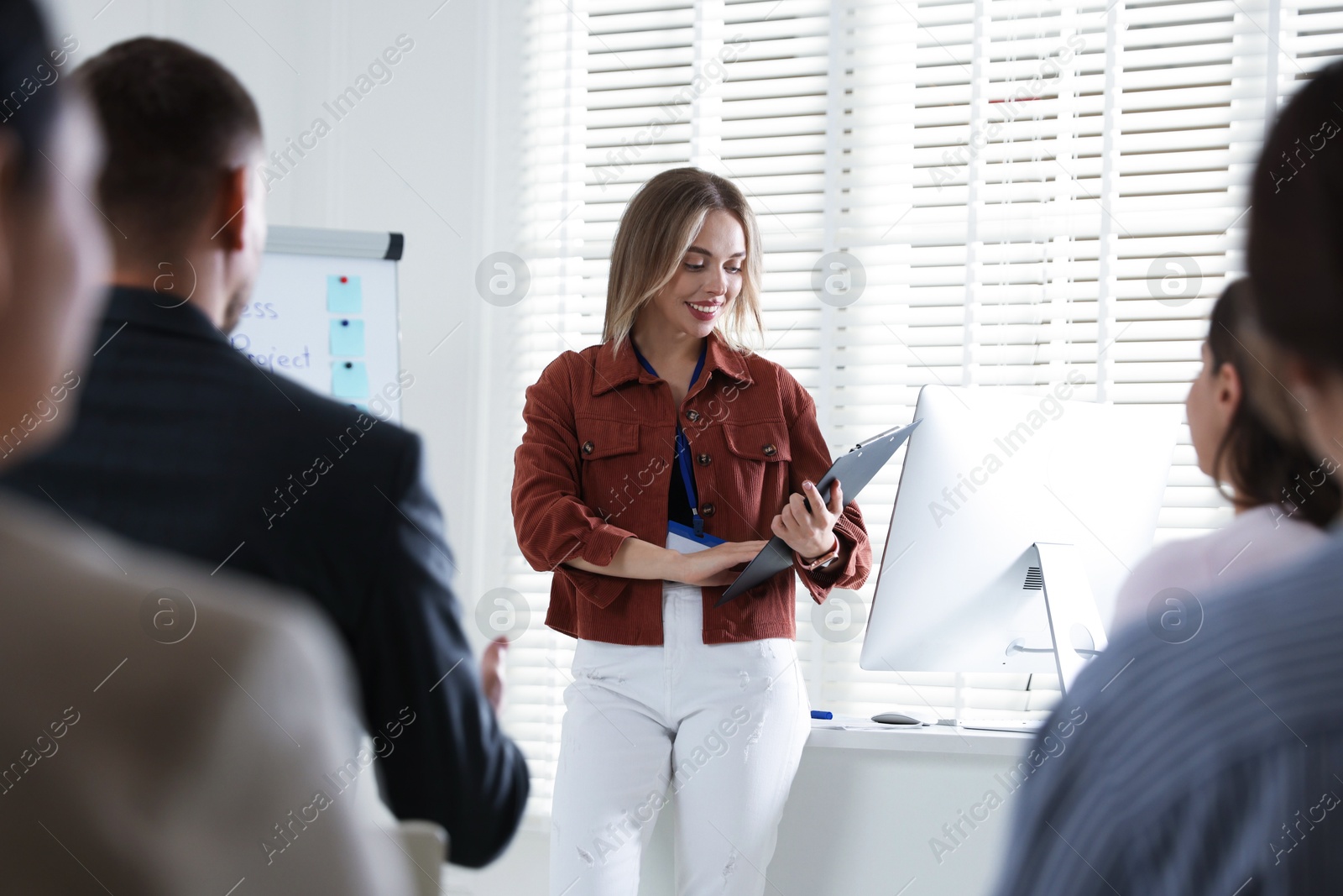 Photo of Woman giving public speech in front of audience indoors
